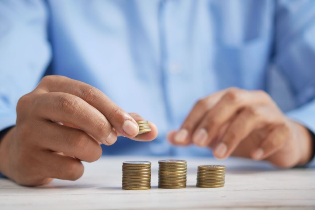 Person stacking coins into piles on a table